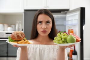 Woman deciding what to eat for dental health.